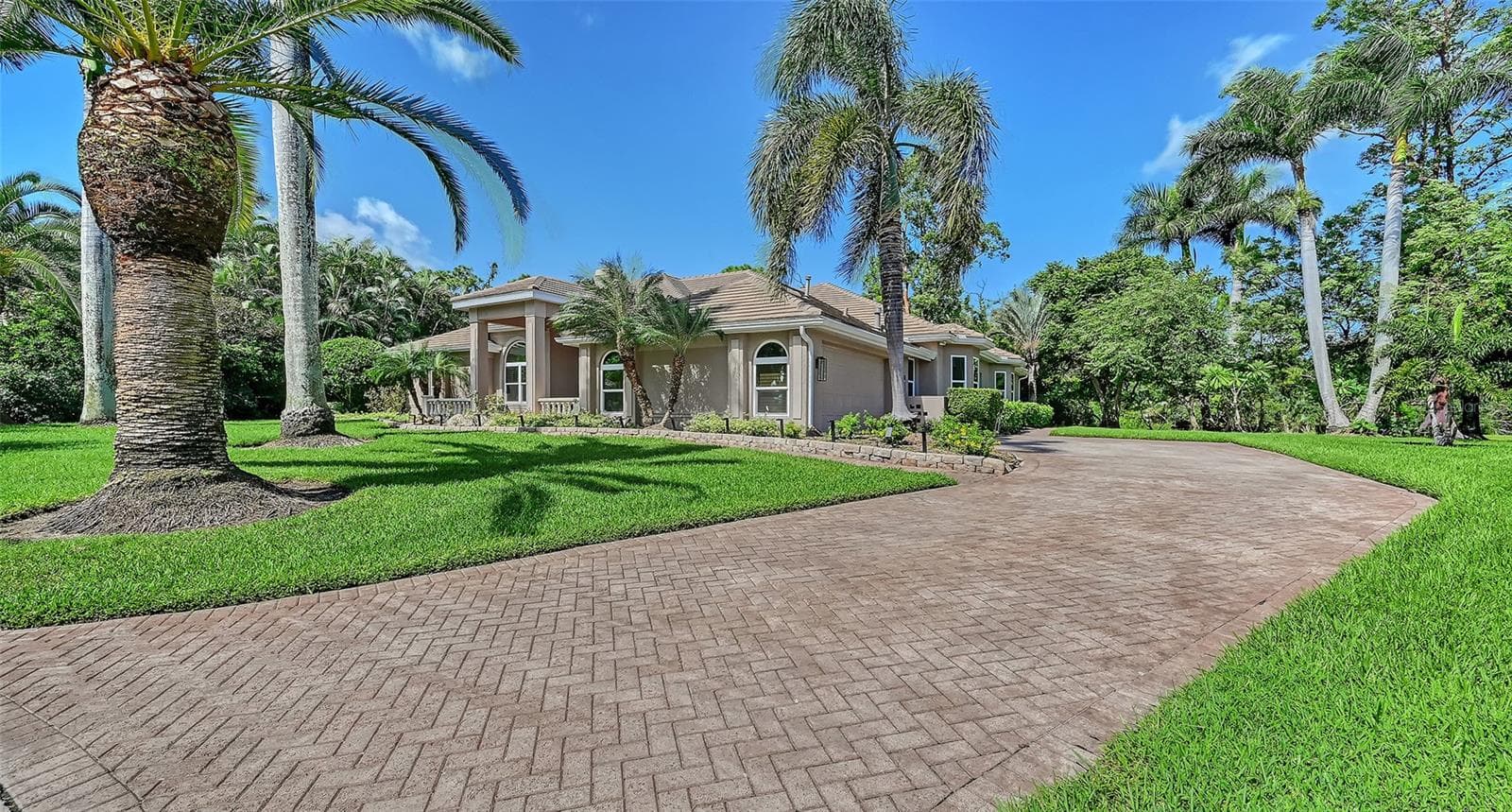 Long paver driveway with the side entry two-car garage. - 8866 BLOOMFIELD BLVD, SARASOTA