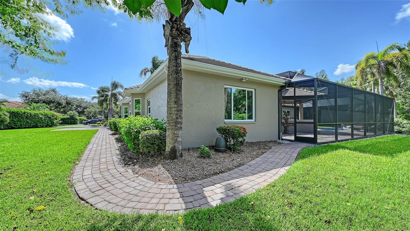 The right side of the home with paver walkway from the front to the pool area. - 8866 BLOOMFIELD BLVD, SARASOTA