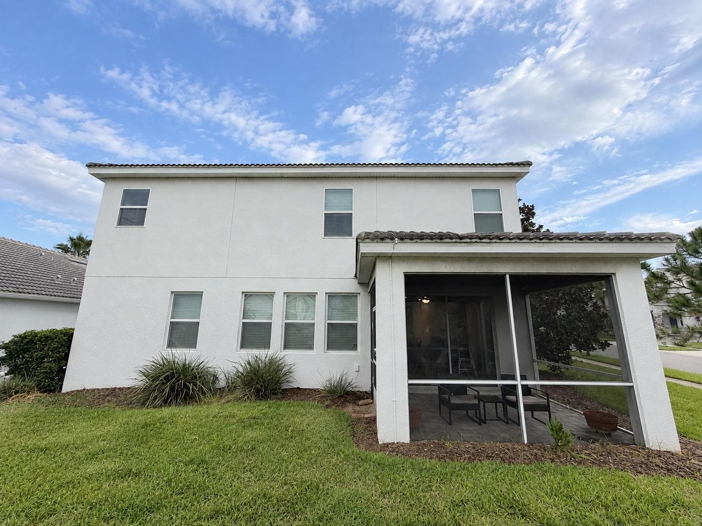 Rear exterior showcases the home's spacious footprint and private screened outdoor living area. - 1516 BUNKER DR, DAVENPORT