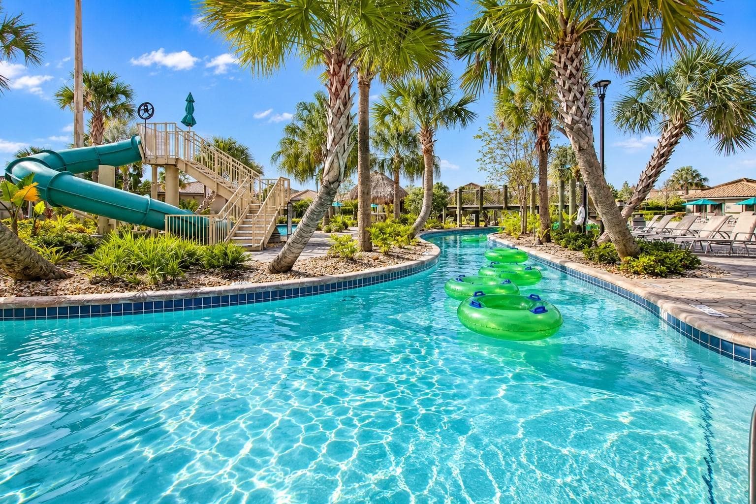Resort-style lazy river surrounded by tropical landscaping, lounge areas and water attractions. - 1516 BUNKER DR, DAVENPORT