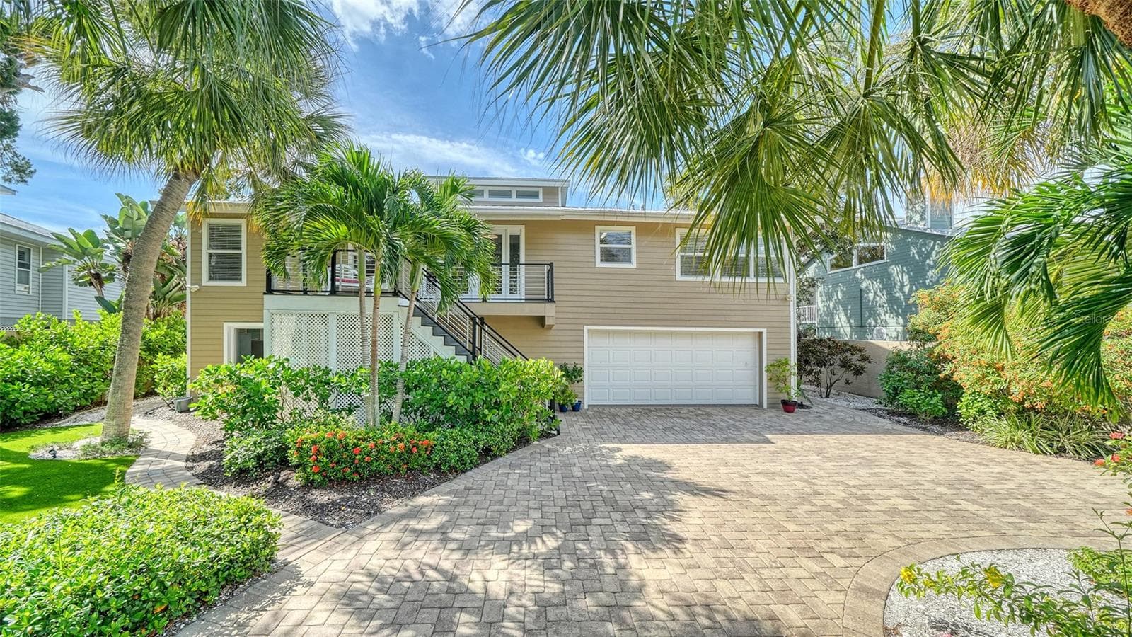 Elevated Key West style home with mature tropical landscaping and an oversized two-car garage. - SARASOTA