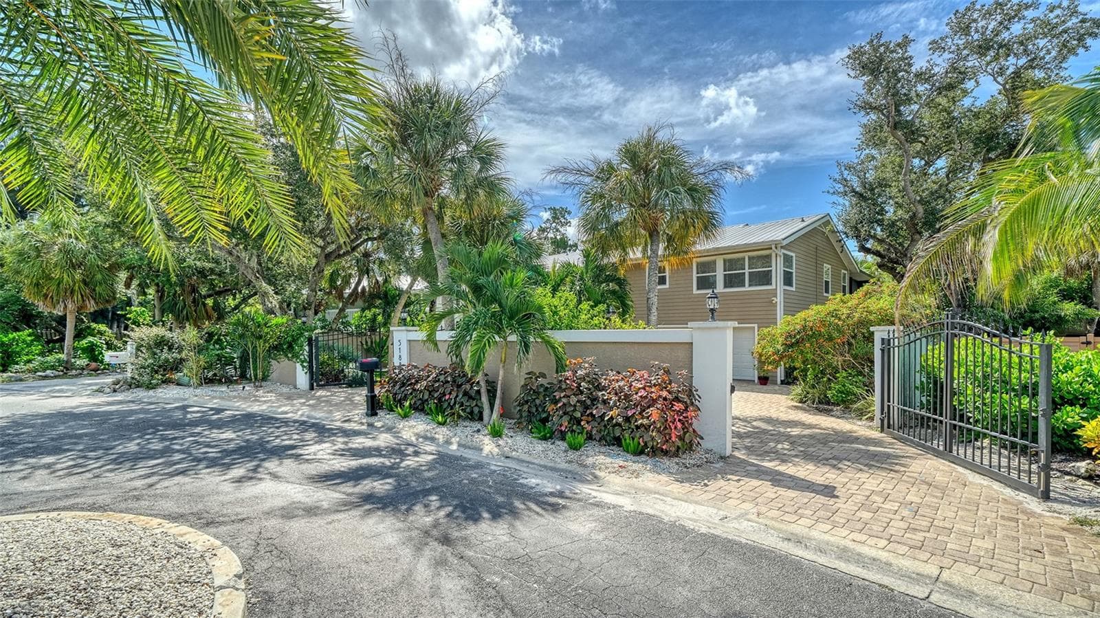 Beautifully landscaped entrance with gated access and a private setting. - SARASOTA