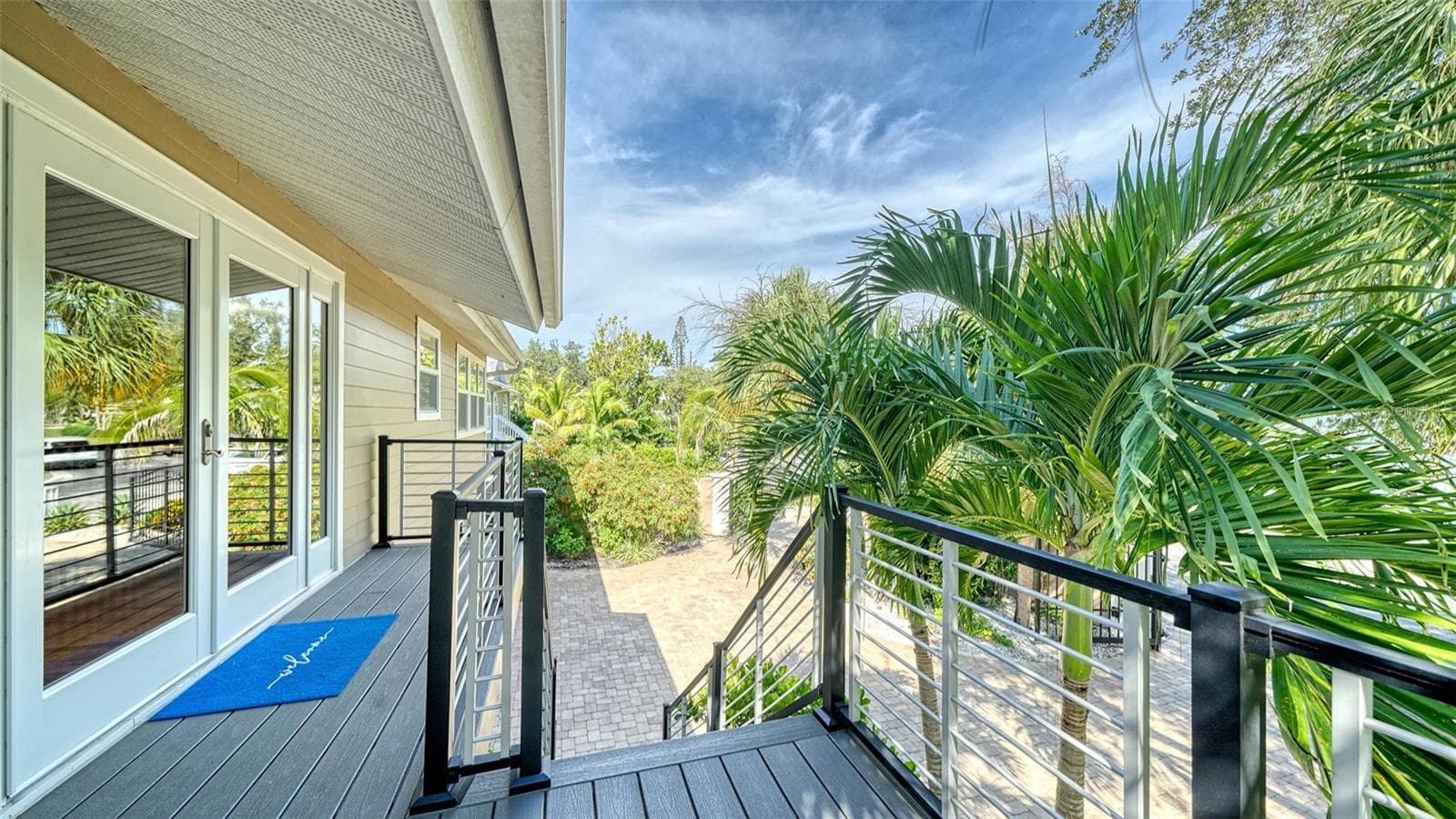 Elevated front entry surrounded by lush tropical foliage. - 5188 SIESTA WOODS DR, SARASOTA