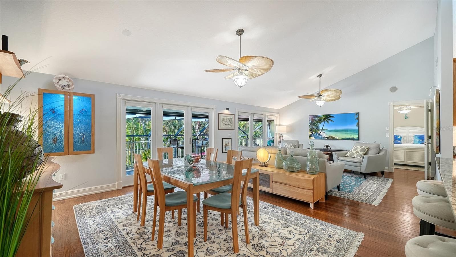 Open concept dining and living areas with hardwood floors and vaulted ceilings. - SARASOTA