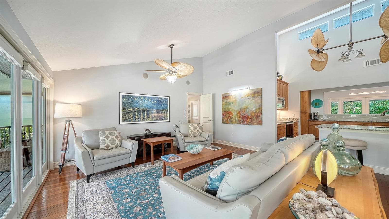 Spacious living room with hardwood floors and access to the covered balcony. - SARASOTA