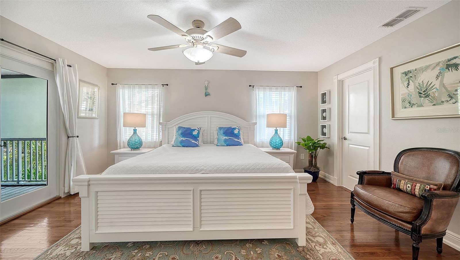 Spacious primary suite with hardwood floors and private balcony access. - SARASOTA