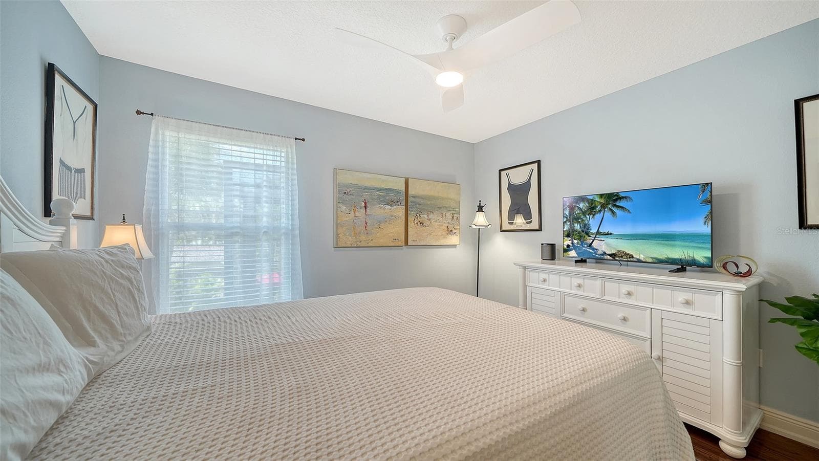 Spacious guest bedroom with ceiling fan and generous closet space. - SARASOTA