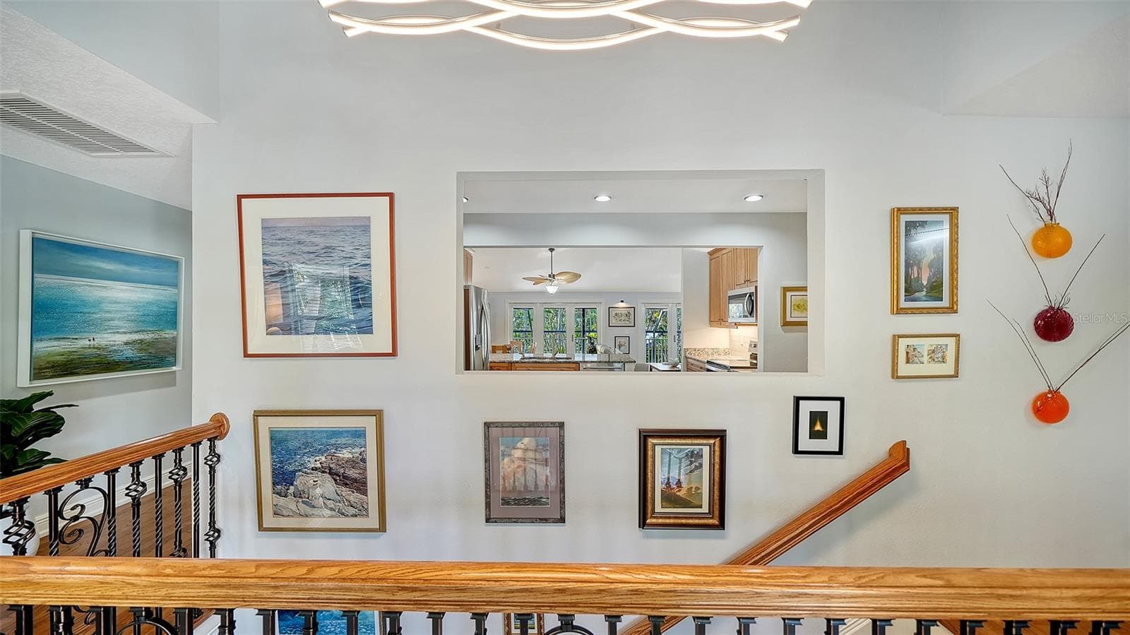 Upper hallway and staircase connecting the home’s two living levels. - SARASOTA