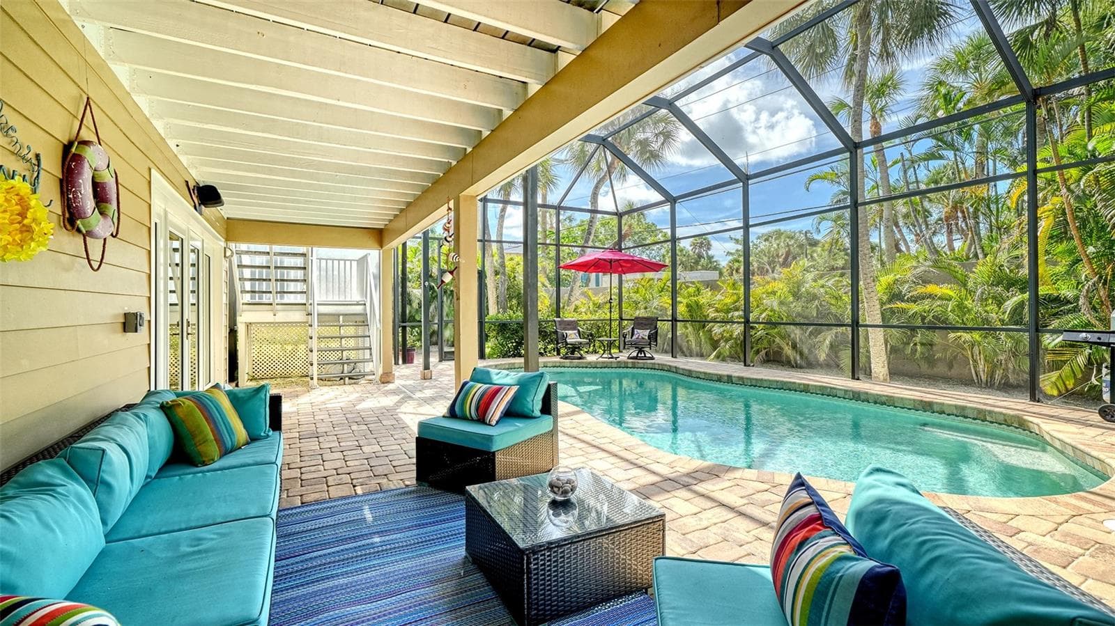 Covered outdoor living area overlooking the heated saltwater pool. - SARASOTA