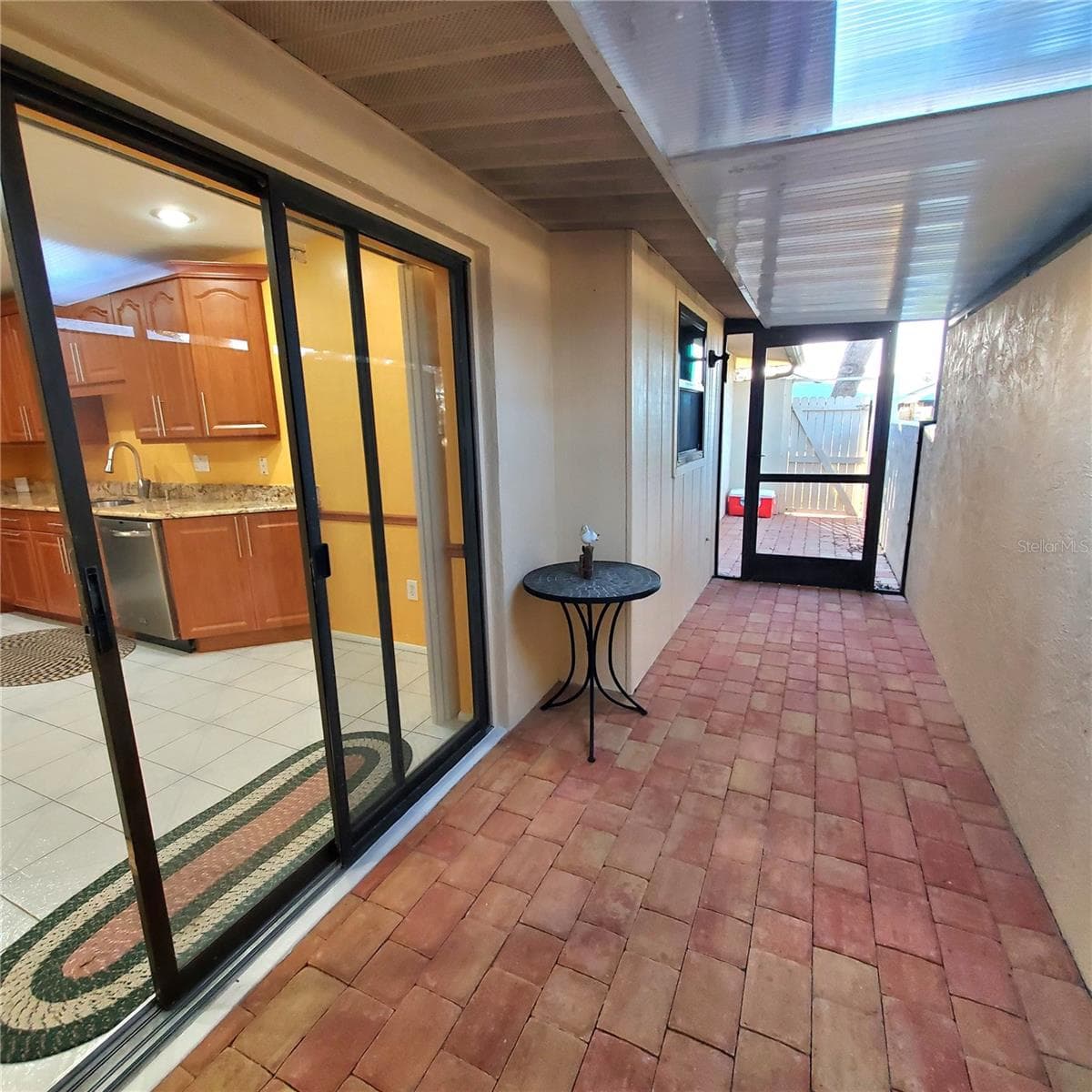 enclosed sitting area with pave stone and screen door to the back. - 49 SANDSTONE CIR, VENICE