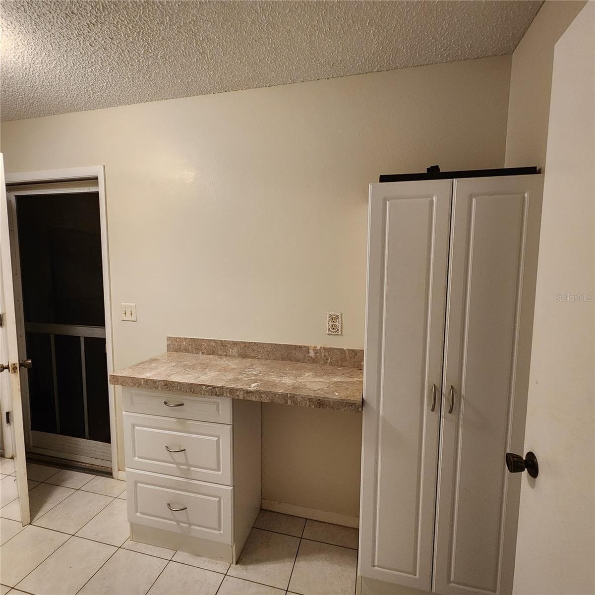 laundry room desk, storage cabinet, and door to garage - 49 SANDSTONE CIR, VENICE