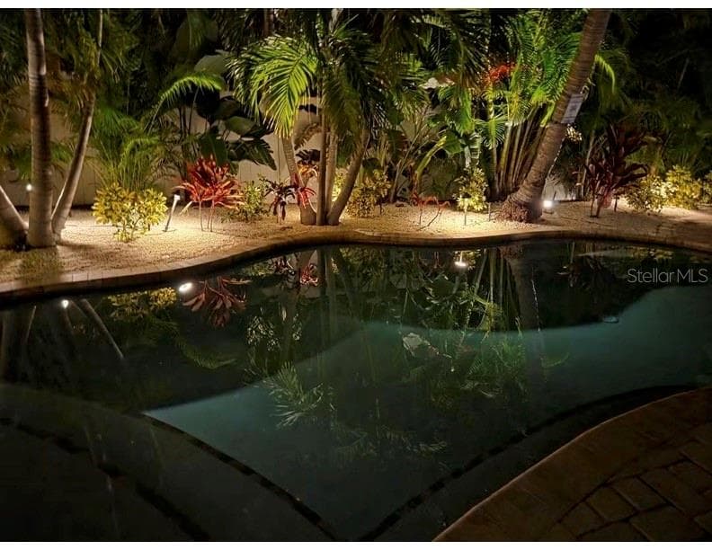 Stunning backyard pool at night, perfect for evening entertaining and relaxation. - 324 64TH ST, HOLMES BEACH
