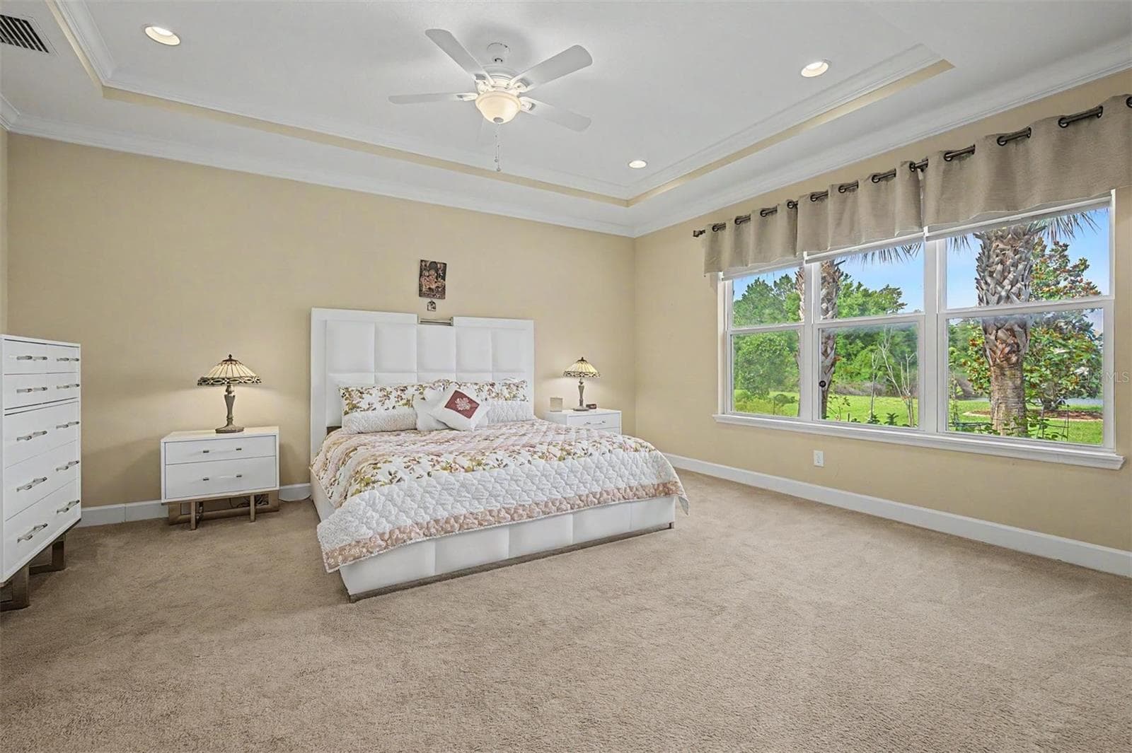 Large primary bedroom with a bank of windows displaying water views - 4303 BARBOUR TRL, ODESSA