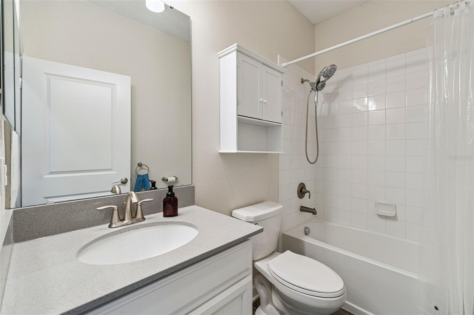 Bathroom 2 features a comfort height vanity with quartz countertops and a tub/shower unit - 4075 BEDFORD AVE, WINTER HAVEN