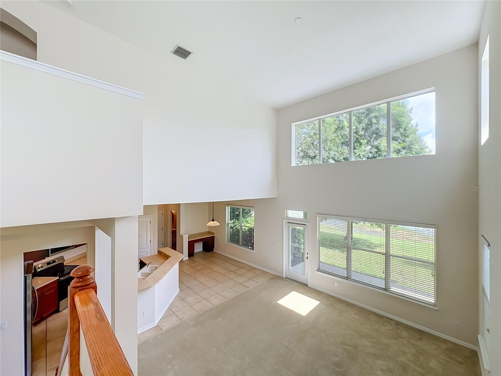 Family living area features lots of light from high ceilings and 2-story windows! Dinette area includes built-in desk, Kitchen features breakfast bar, New appliances, wood cabinets, and closet pantry - 12809 HOLDENBURY LN, WINDERMERE