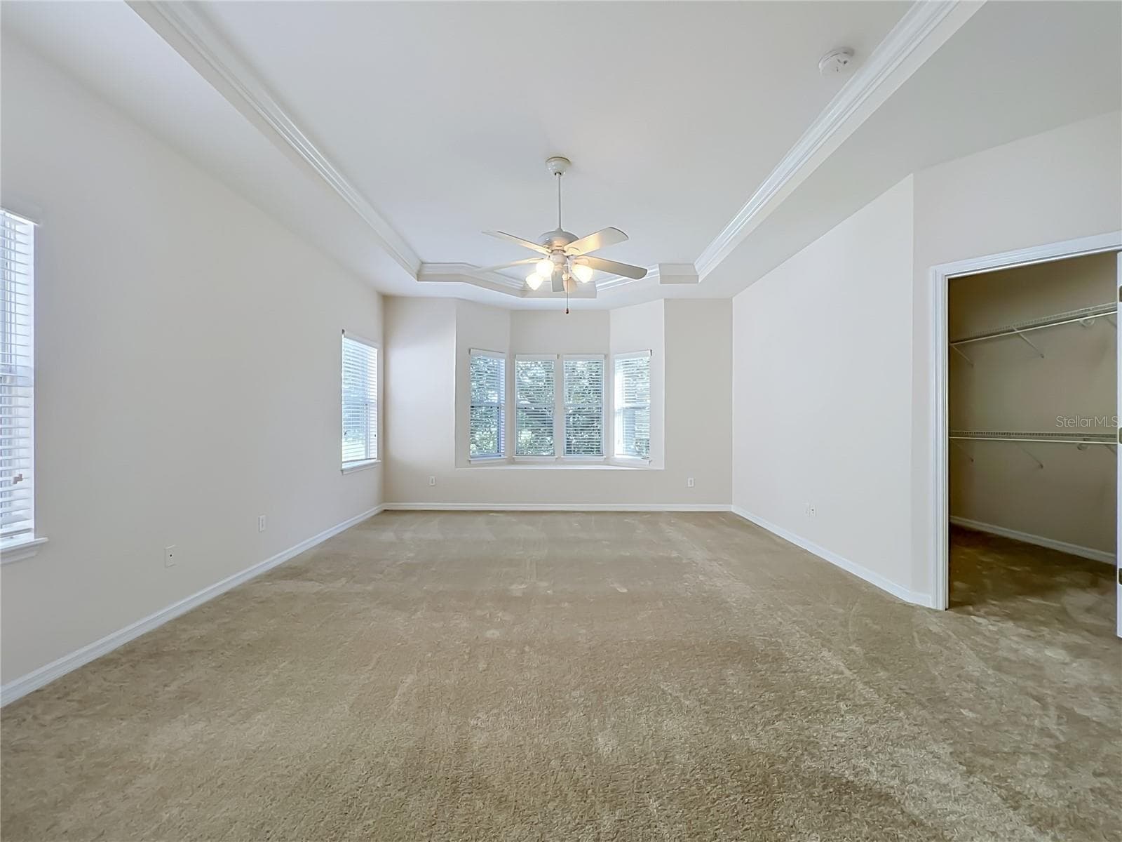 Primary bedroom features window seat, ceiling fan, tray ceiling, and large walk-in closet - 12809 HOLDENBURY LN, WINDERMERE