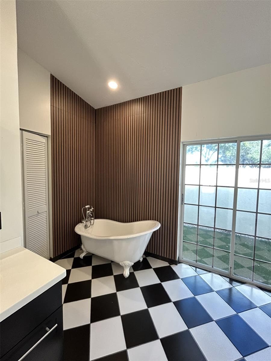 Rich wood paneling with a danity claw foot tub. - 4415 HIGHLAND OAKS CIR, SARASOTA