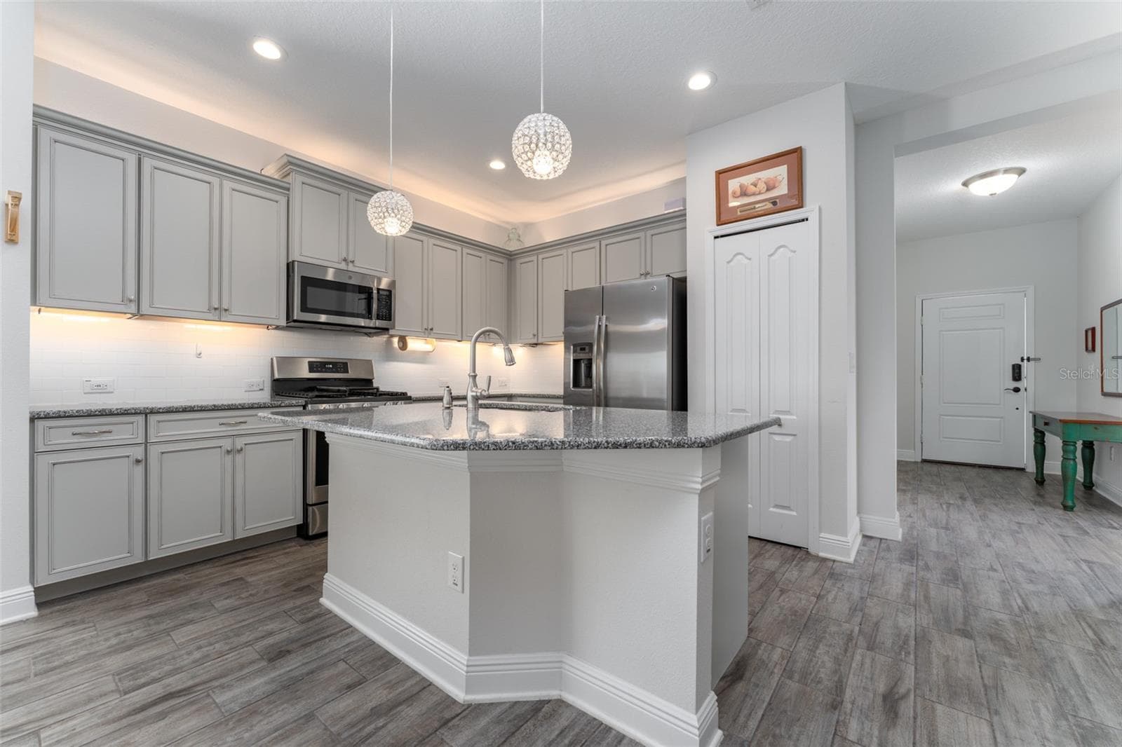 Kitchen with Center Island, Granite Tops, Neutral Cabinetry, Tile Backsplash & SS GE Appliances - 13533 CIRCA CROSSING DR, LITHIA