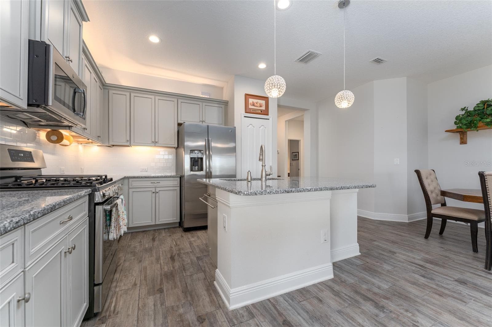 Kitchen with Center Island, Granite Tops, Neutral Cabinetry, Tile Backsplash & SS GE Appliances - 13533 CIRCA CROSSING DR, LITHIA