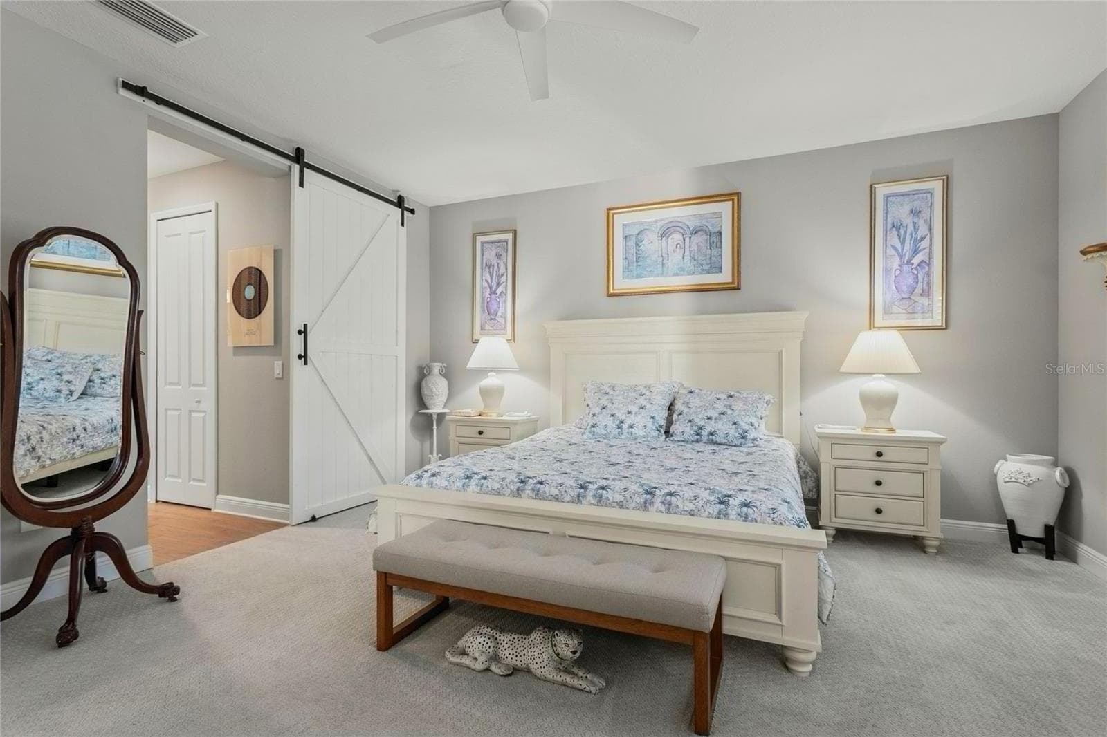 Primary bedroom with soft neutral tones, plantation shutters, carpeted flooring, and a spacious, serene layout designed for comfort and privacy. - 10625 FALLING LEAF CT, PARRISH