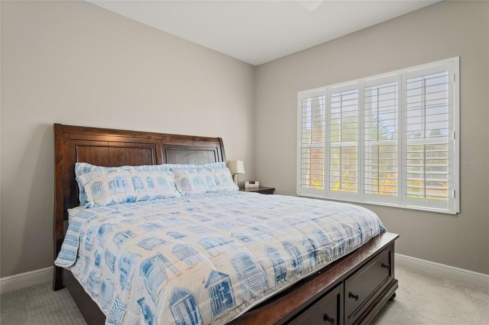 Downstairs comfortable-sized bedroom located toward the front of the house, featuring plantation shutters, neutral finishes, and a versatile layout. - 10625 FALLING LEAF CT, PARRISH