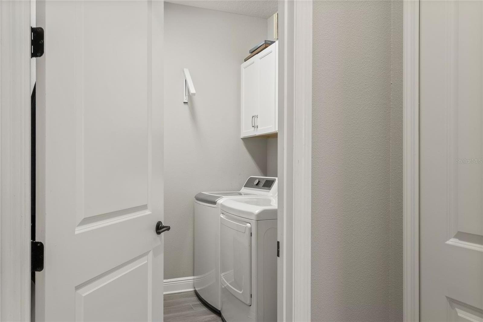 Ample walk-in laundry room with work sink, upper storage, and a functional layout designed for everyday convenience - 10625 FALLING LEAF CT, PARRISH