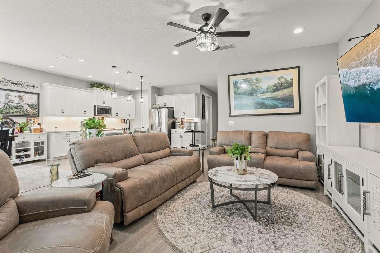 Spacious living area that forms part of the open layout connecting the kitchen, dining, and living room, with bright natural light and direct access to the pool area for seamless indoor-outdoor living - 10625 FALLING LEAF CT, PARRISH