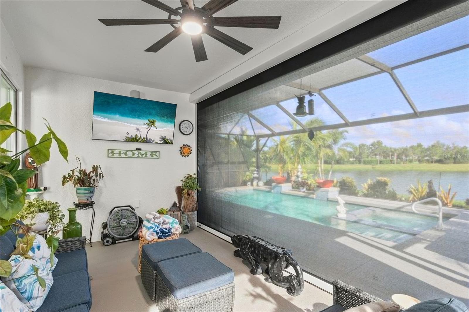 Retractable hurricane shutter that can be closed partially or fully, providing flexible protection and privacy while maintaining a seamless connection to the pool and lake views - 10625 FALLING LEAF CT, PARRISH