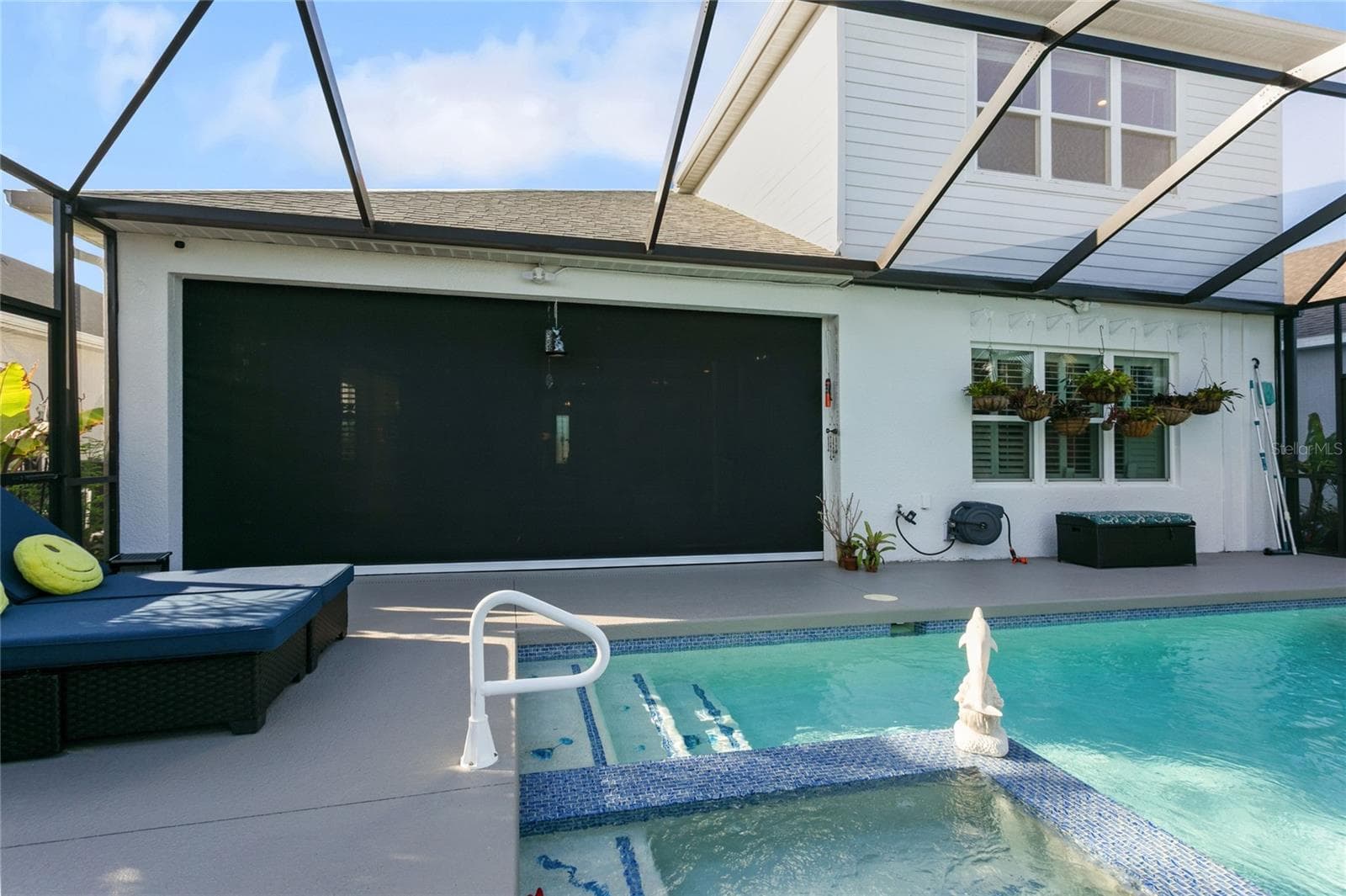 The lanai is equipped with hurricane shutters that can be fully or partially closed, providing flexible protection while preserving the panoramic screened-in view of the pool and lake - 10625 FALLING LEAF CT, PARRISH