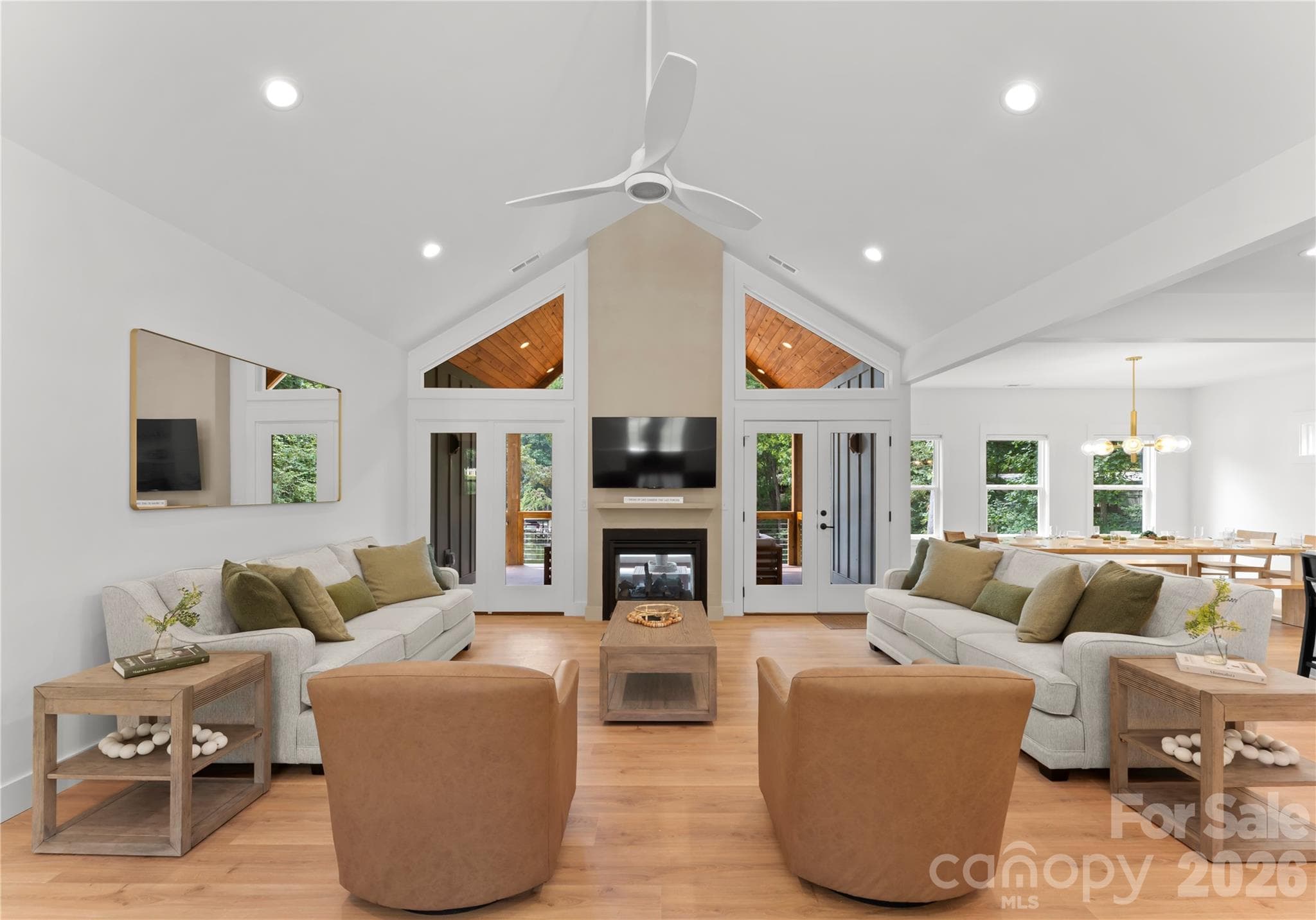 A true Great Room with vaulted ceiling, fireplace, and generous windows bring light and character to the home, with large doors that open onto to the covered porch. - 143 Hideaway Lane, Mooresville