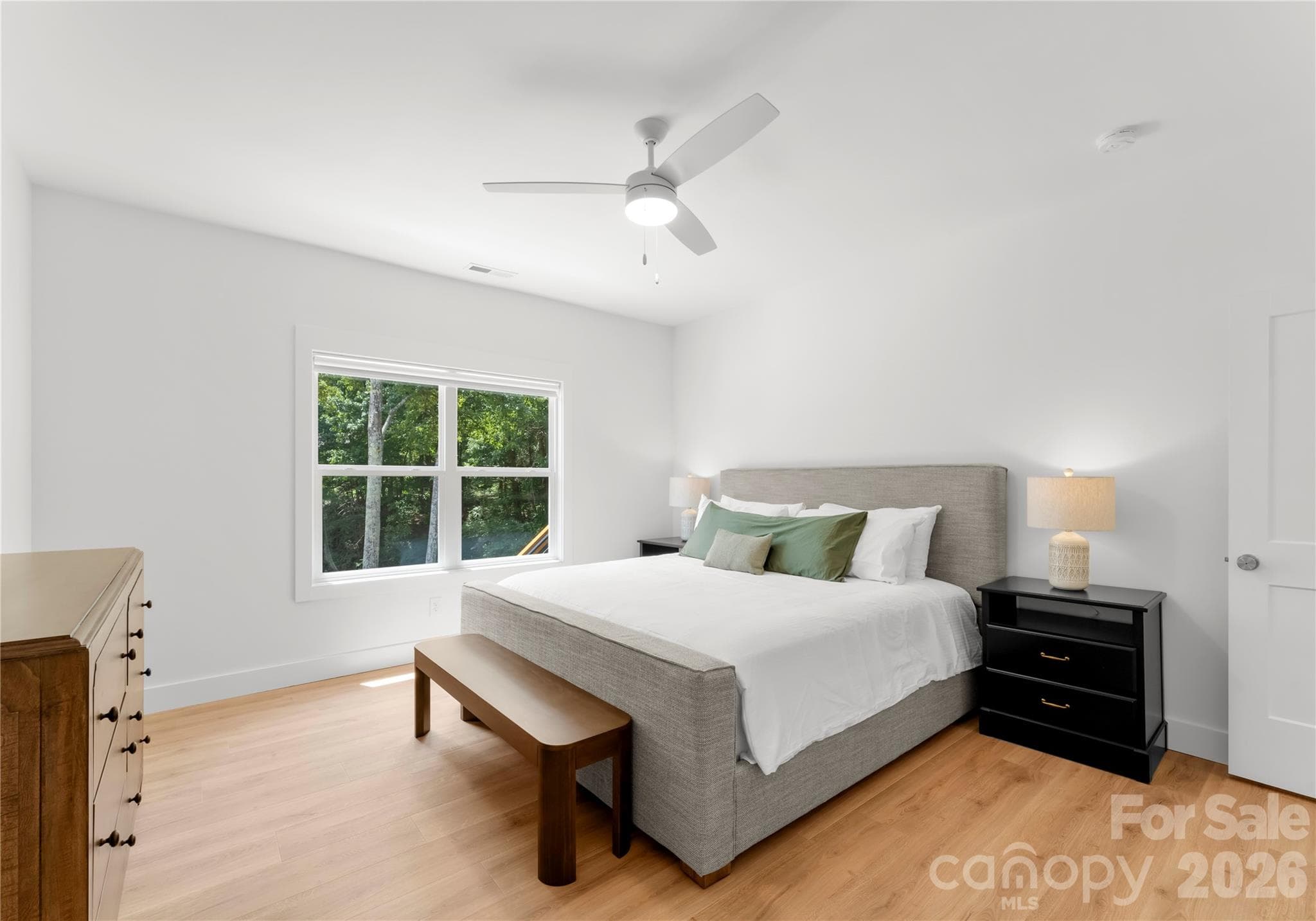 The Primary bedroom, set on the main floor just off the living area, provides a serene and tranquil refuge with stunning views across the property to the lake and beyond. - 143 Hideaway Lane, Mooresville