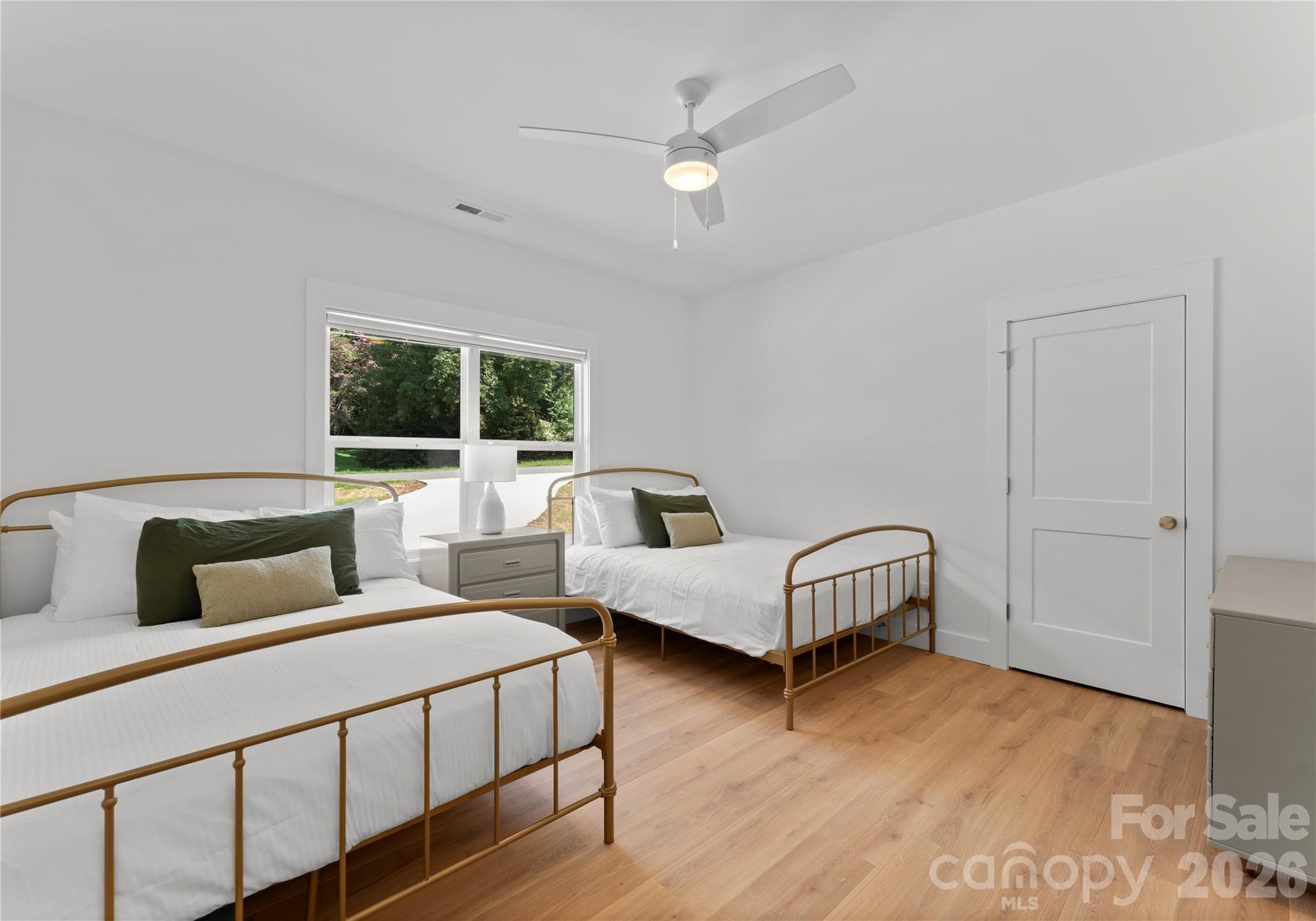 This light-filled bedroom offers two beds and an easy, welcoming place for guests to settle in. - 143 Hideaway Lane, Mooresville