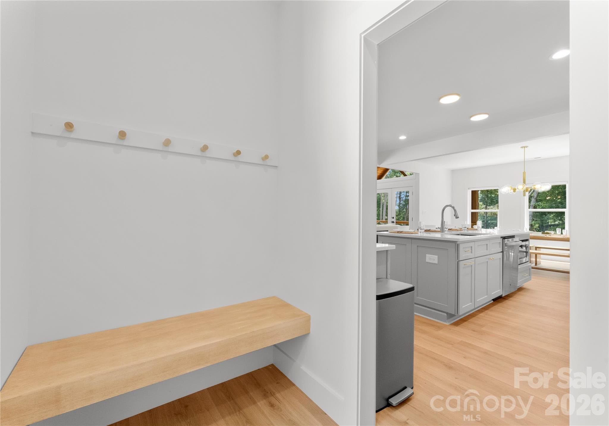 A built-in bench and wall hooks create a practical landing spot for bags and towels after a day at the lake. - 143 Hideaway Lane, Mooresville
