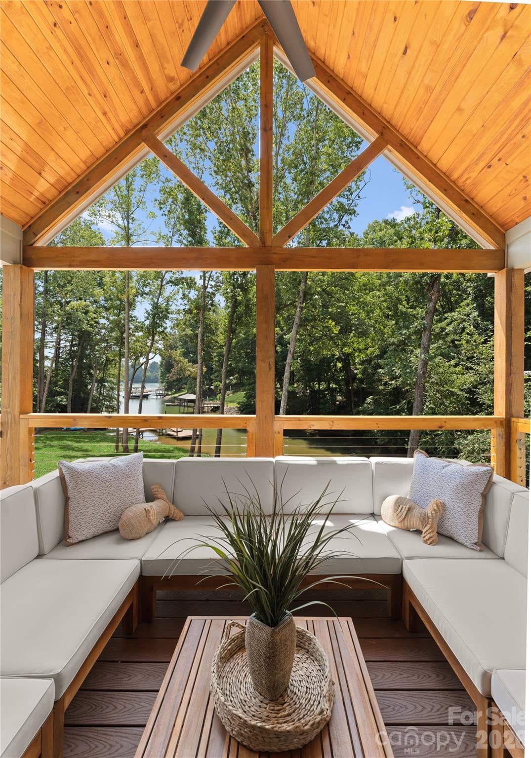 Settle in beneath the vaulted porch ceiling and enjoy a view through the trees to the dock and water. - 143 Hideaway Lane, Mooresville