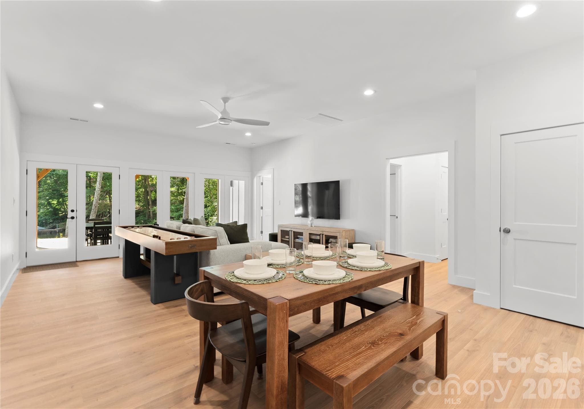 The open layout connects the downstairs dining area and lounge, with doors leading outside to the backyard. - 143 Hideaway Lane, Mooresville