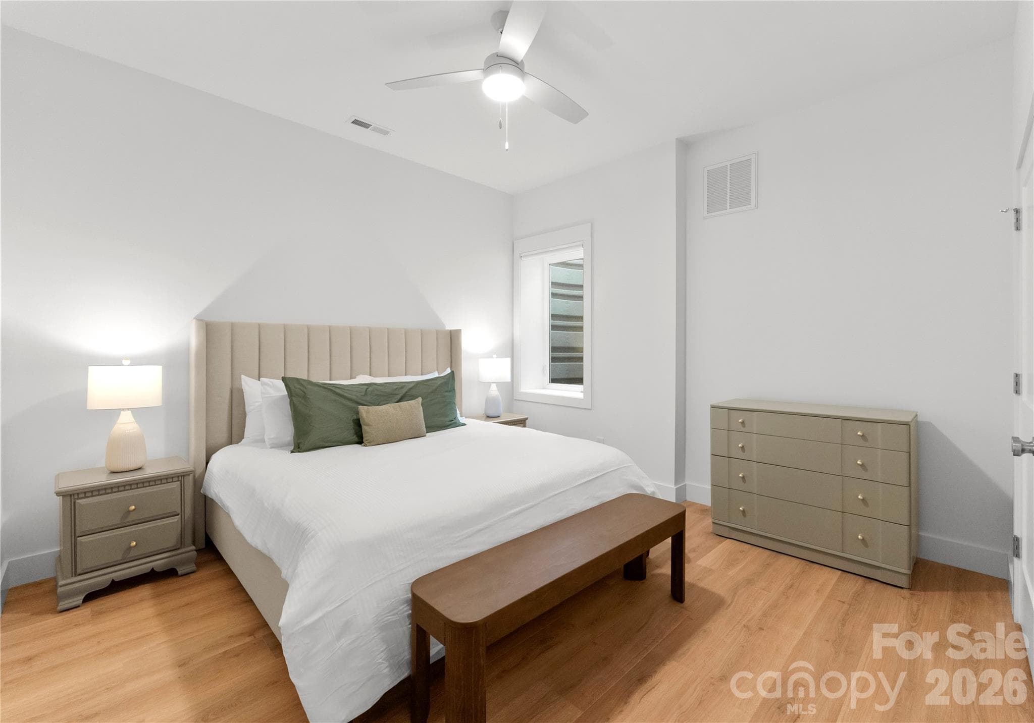 Soft neutral finishes and warm wood floors make this bedroom a restful place to unwind after a day on the lake - 143 Hideaway Lane, Mooresville