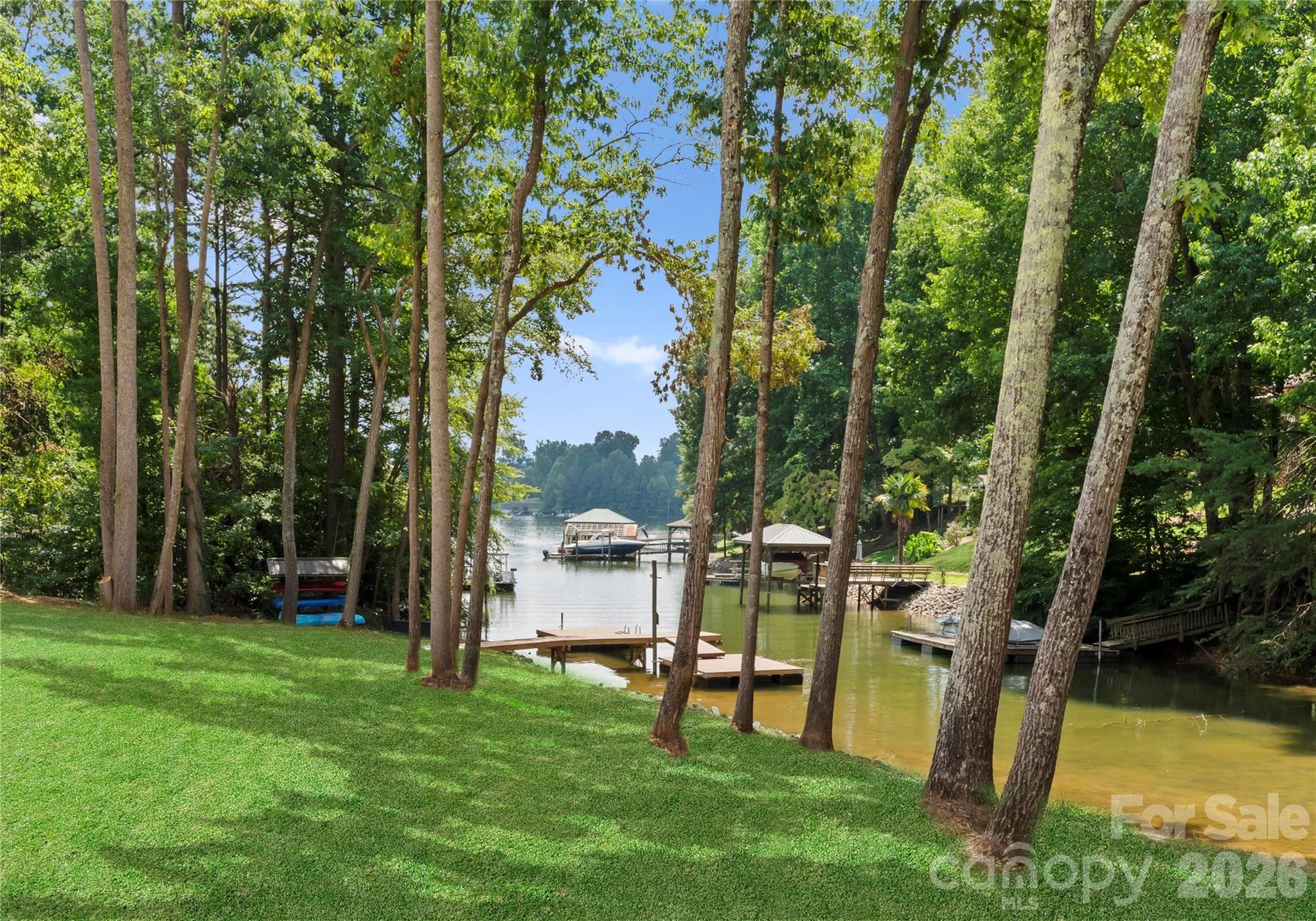 Mature trees frame the lawn and dock, creating a peaceful connection between the home and the water. - 143 Hideaway Lane, Mooresville