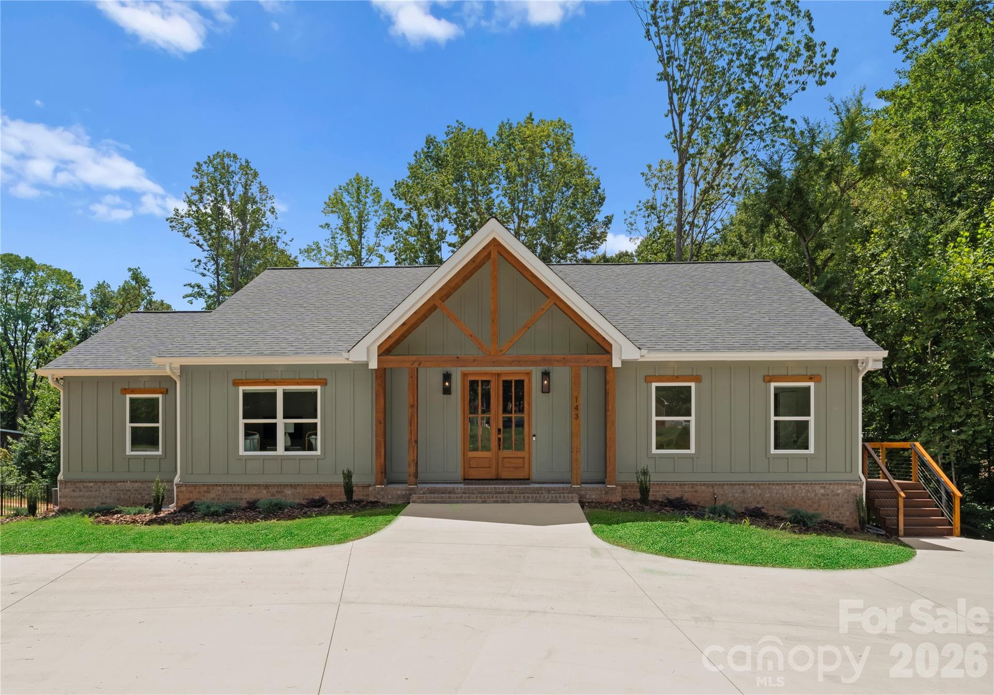 The home’s large circular drive creates a warm, welcoming first impression. Its understated facade offers only a hint of the grandeur of the home and property beyond. - 143 Hideaway Lane, Mooresville
