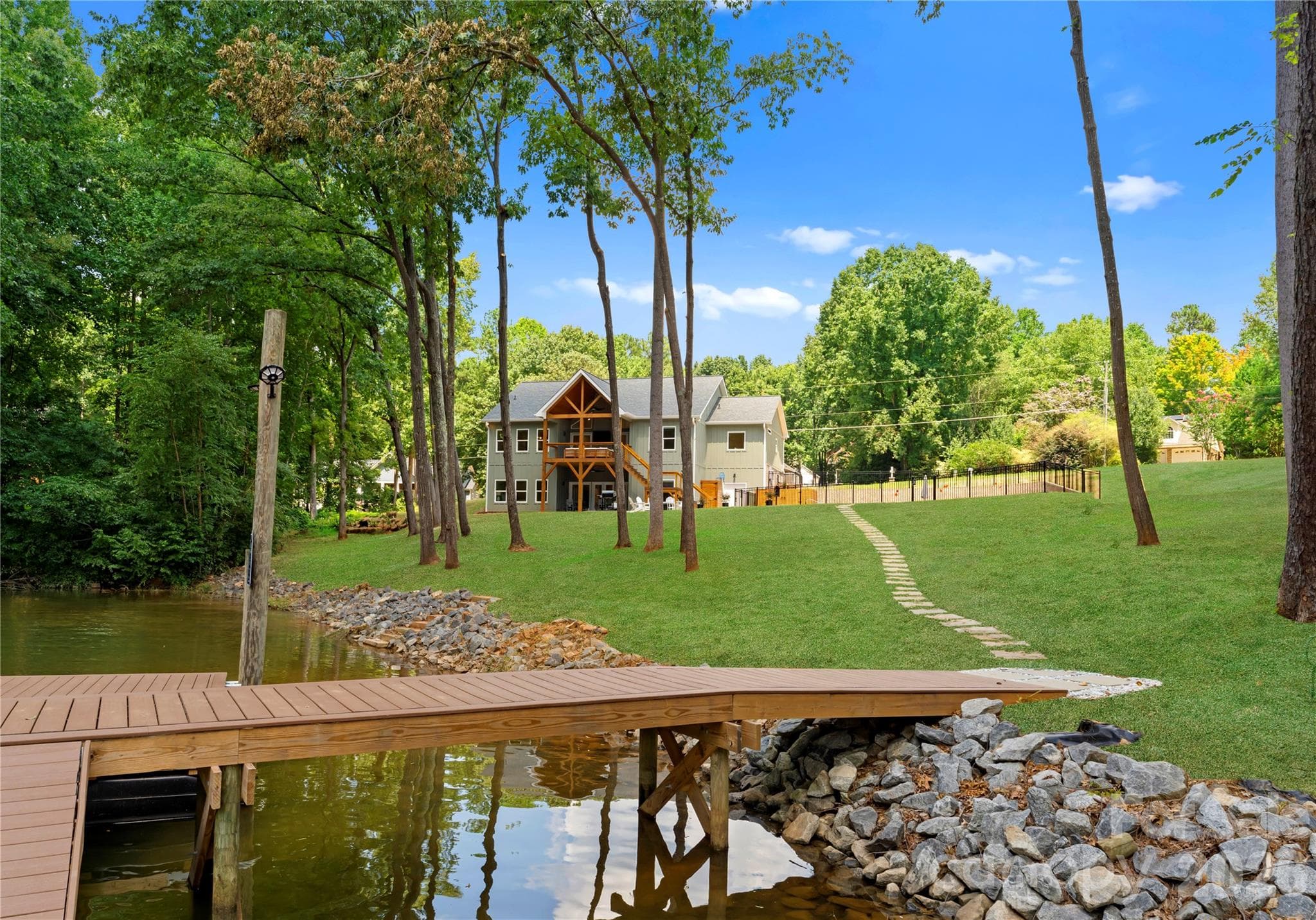 A look back across the property, up the lawn to the pool enclosure and beautiful timber framed porch. - 143 Hideaway Lane, Mooresville