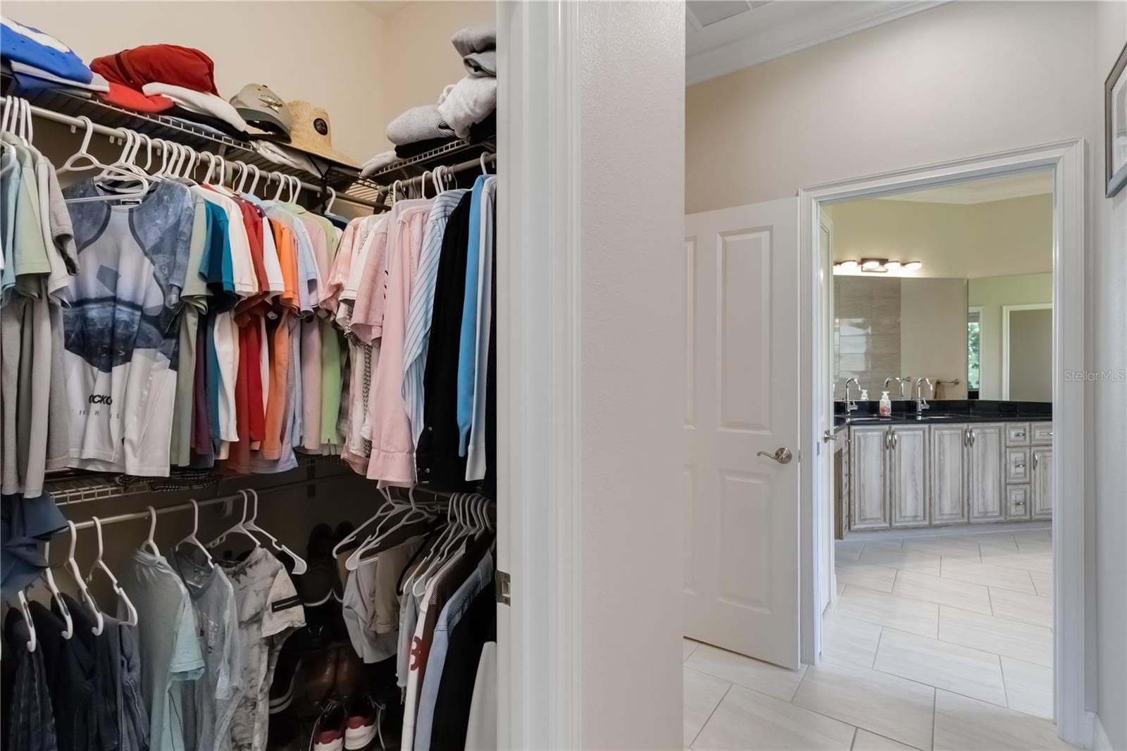 One of two closets in the primary bedroom. The door to the left leads to the great room. Pocket doors separate the primary bathroom from the rest of the primary suite. - 1991 HEASLEY, ENGLEWOOD