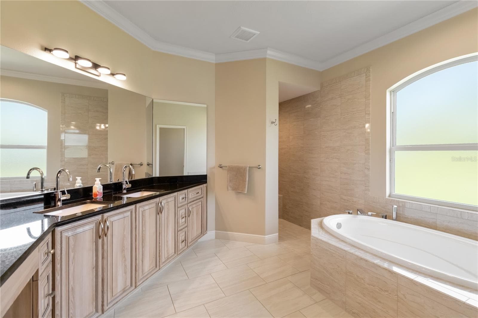 Primary bathroom with ample counter space, double sinks and granite counters. The walk-in shower and soaking tub are pictured here. There is also a separate room for the toilet and a linen closet in this space. - 1991 HEASLEY, ENGLEWOOD