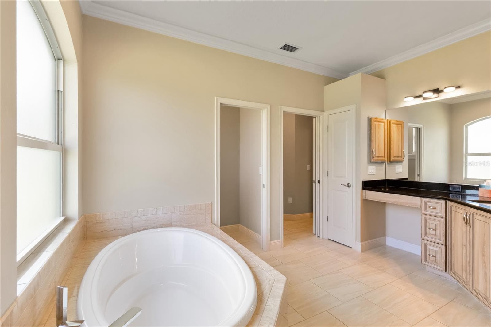 View of soaking tub, toilet room (left pocket door), linen closet, and right opening (also a pocket door) leads to the primary bedroom. - 1991 HEASLEY, ENGLEWOOD