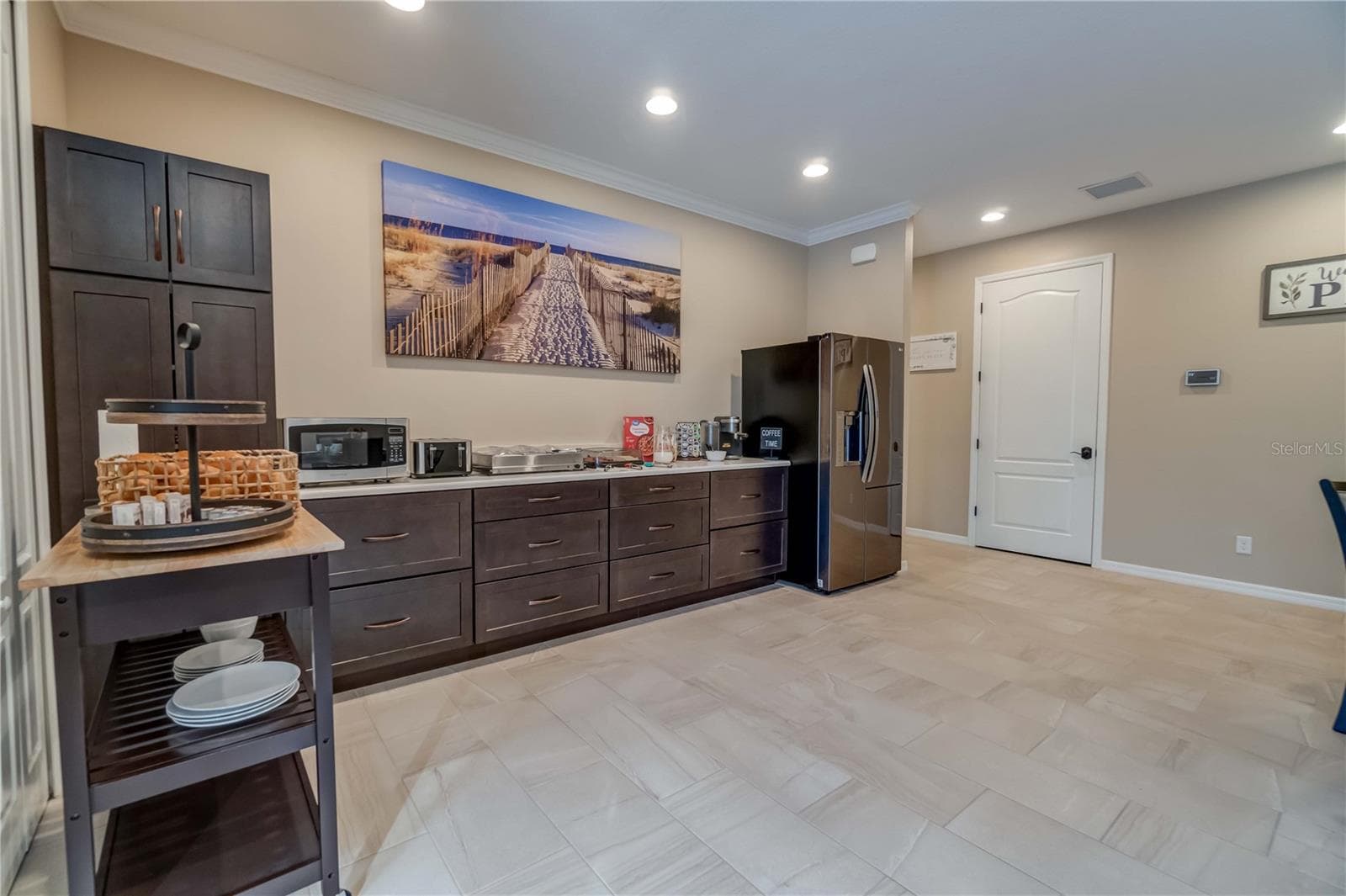 This is the other half of the gathering room and where the sellers served their guests breakfast each morning. The custom cabinets are maple. The counters are quartz. The white door leads to the air conditioner room with additional storage. - 1991 HEASLEY, ENGLEWOOD