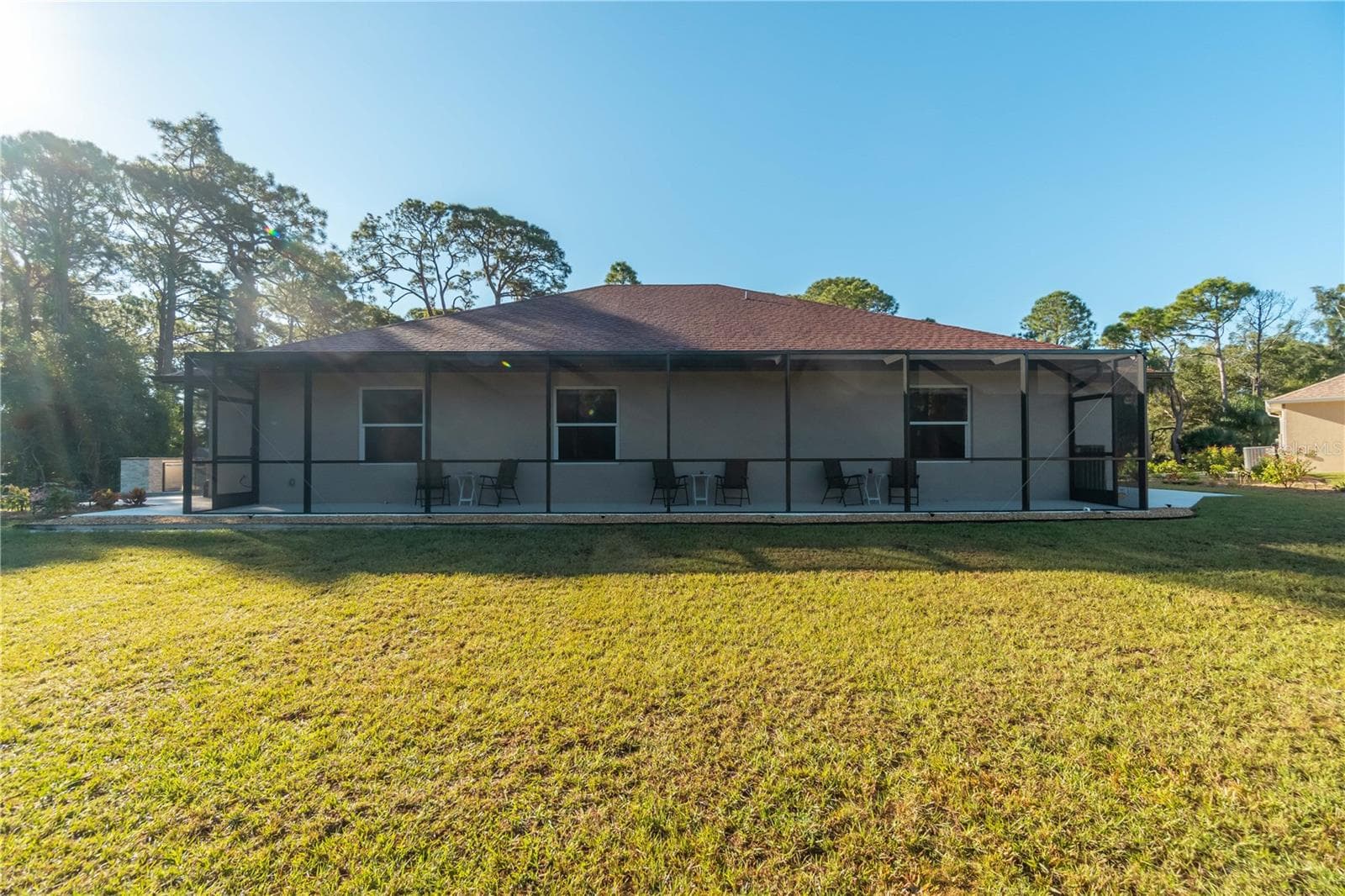 This is the lanai in the guest house mentioned earlier. The lanai overlooks the pond, fire pit and part of the yard. The three windows belong to suites 1,2 and 3. These suites have access to the lanai. To the left is the outdoor kitchen specific to the guest house and available for the guests. - 1991 HEASLEY, ENGLEWOOD
