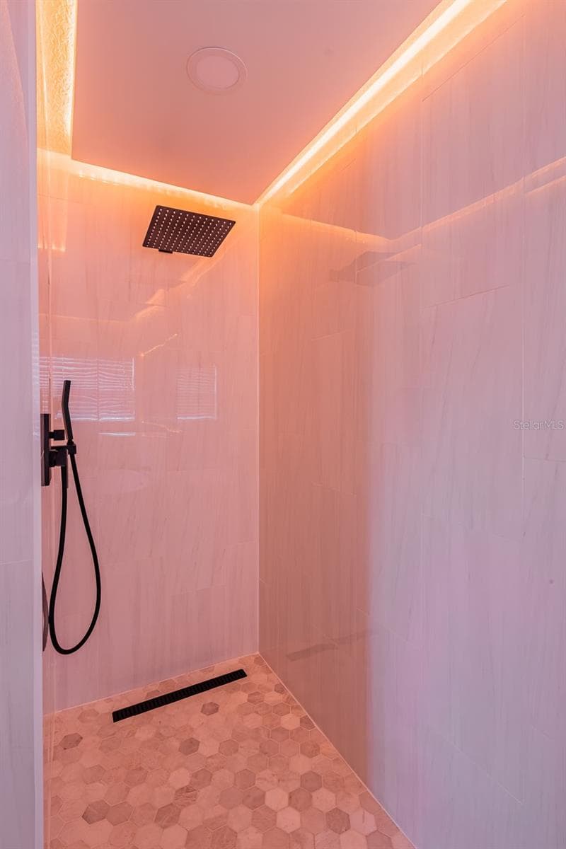 Completely gutted and rebuilt in 2022 with an investment of approximately $32,000, the primary bathroom includes a floating quartz double vanity, illuminated mirrors, an oversized walk in rain shower, multiple shower fixtures and lighted niches. - 14585 CHEEVER ST, ORLANDO