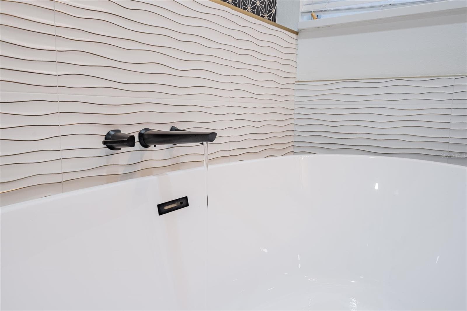 Completely gutted and rebuilt in 2022 with an investment of approximately $32,000, the primary bathroom includes a floating quartz double vanity, illuminated mirrors, an oversized walk in rain shower, multiple shower fixtures and lighted niches. - 14585 CHEEVER ST, ORLANDO