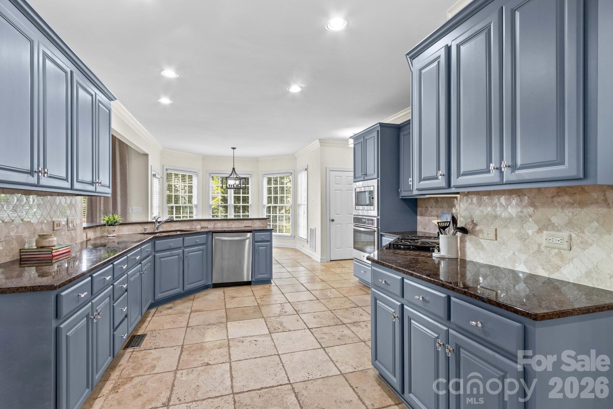 Kitchen features granite counters, tile backsplash, gas cooktop, travertine floors. - 12822 Cadgwith Cove Drive, Huntersville