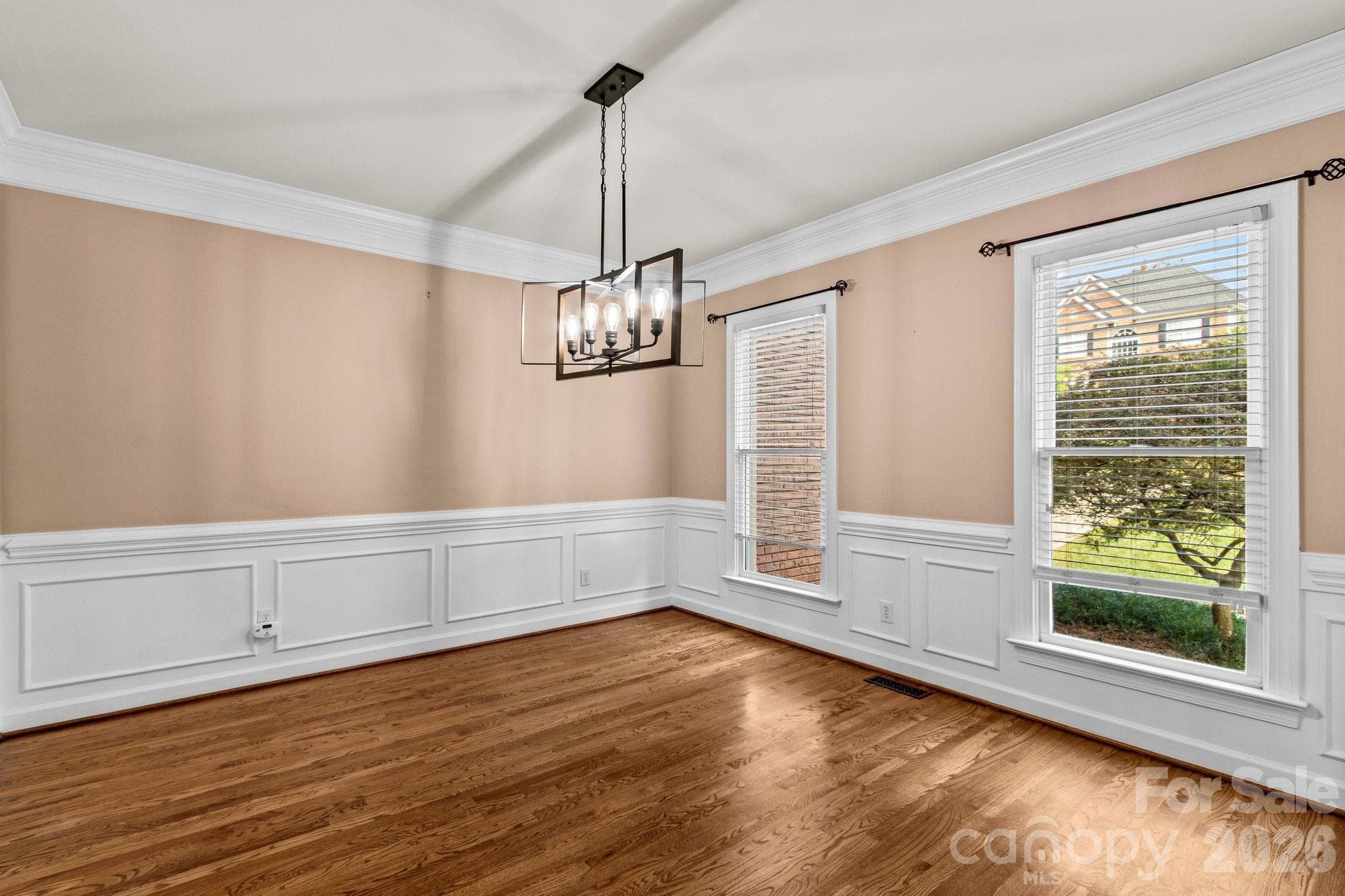 Formal dining room showcases wainscoating, crown molding, and hardwood floors. - 12822 Cadgwith Cove Drive, Huntersville