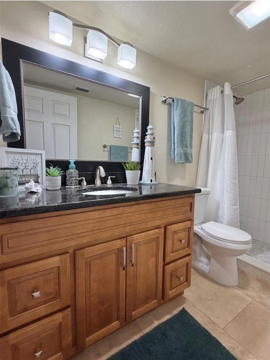 The primary ensuite features travertine floors, solid wood cabinets, granite counters, updated lighting, an updated mirror, and a newly remodeled walk-in shower. - 3815 N OAK DR #G71, TAMPA