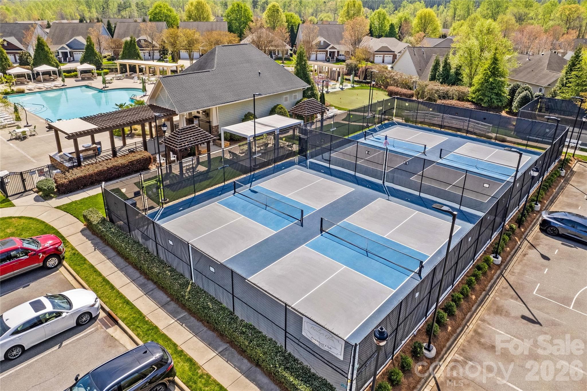 View of pickleball courts next to pool with putting green in the back - 18114 Ebenezer Drive, Cornelius